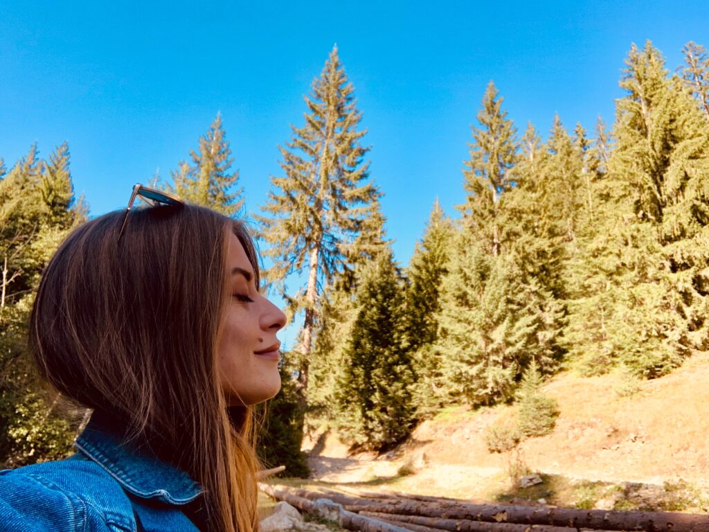 Image of a woman in the forest on a sunny day.