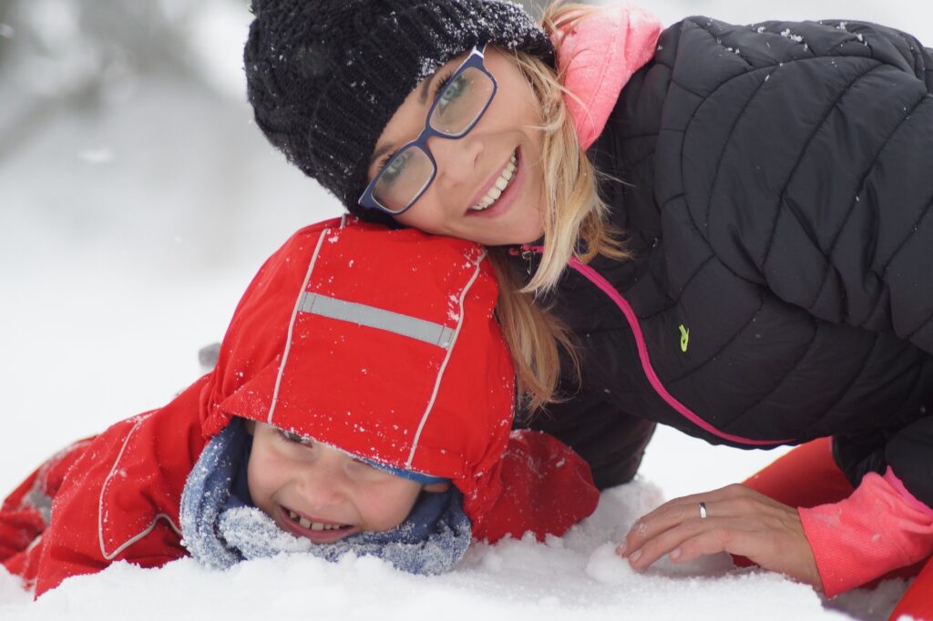 Image of mother and child playing in the snow.