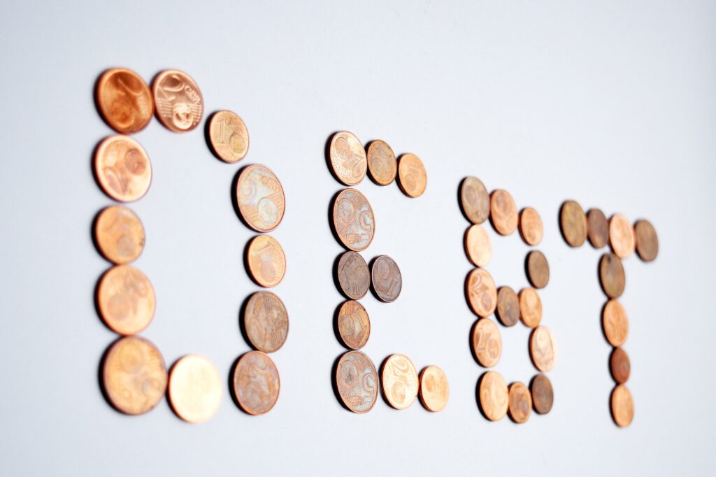 Image of coins spelling out the word debt.