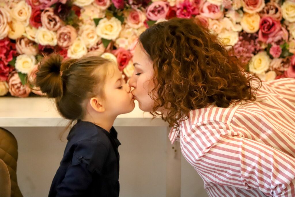 Image of a mother kissing her daughter.