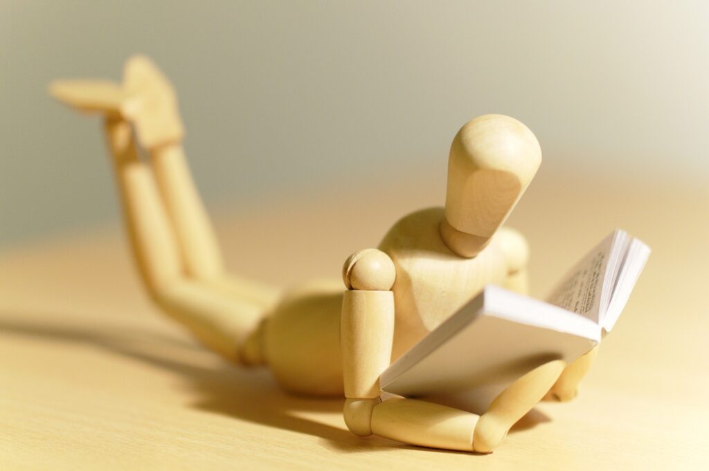 Image of wooden dude reading