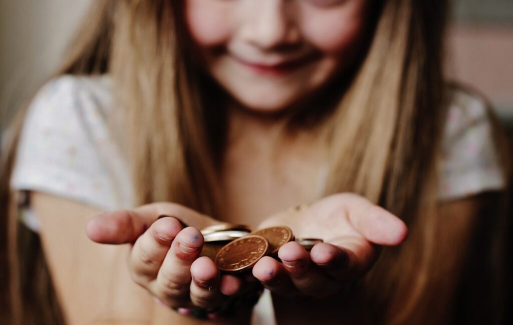 Image of a girl holding coins. budgeting.