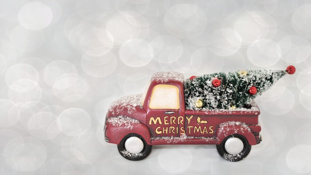 Merry Christmas. An image of a truck with a Christmas tree and "Merry Christmas" on the side.